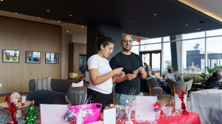Two residents participate in an event inside Two Clinton Park's lounge